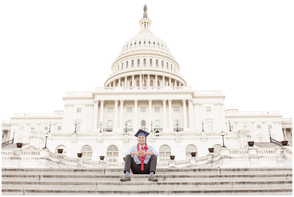 Recent American University graduate sits on the steps of the US Capitol building
