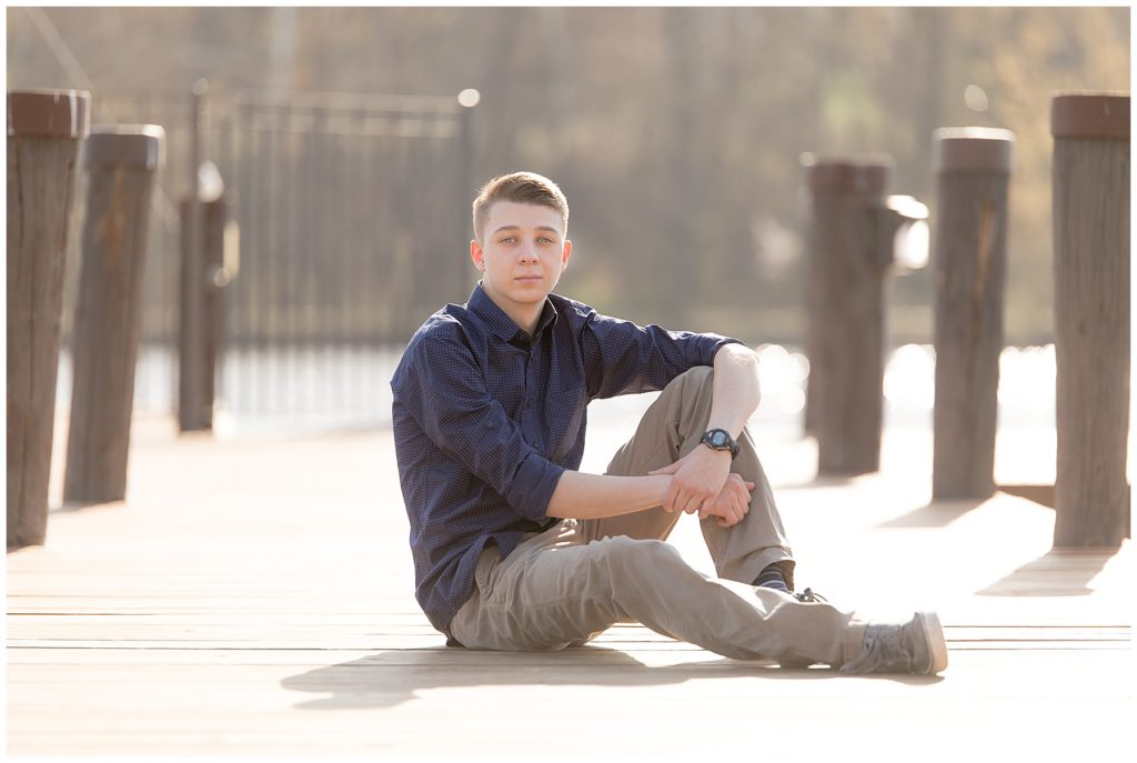 Teen lounges on Columbia, MD, area dock for senior session photos