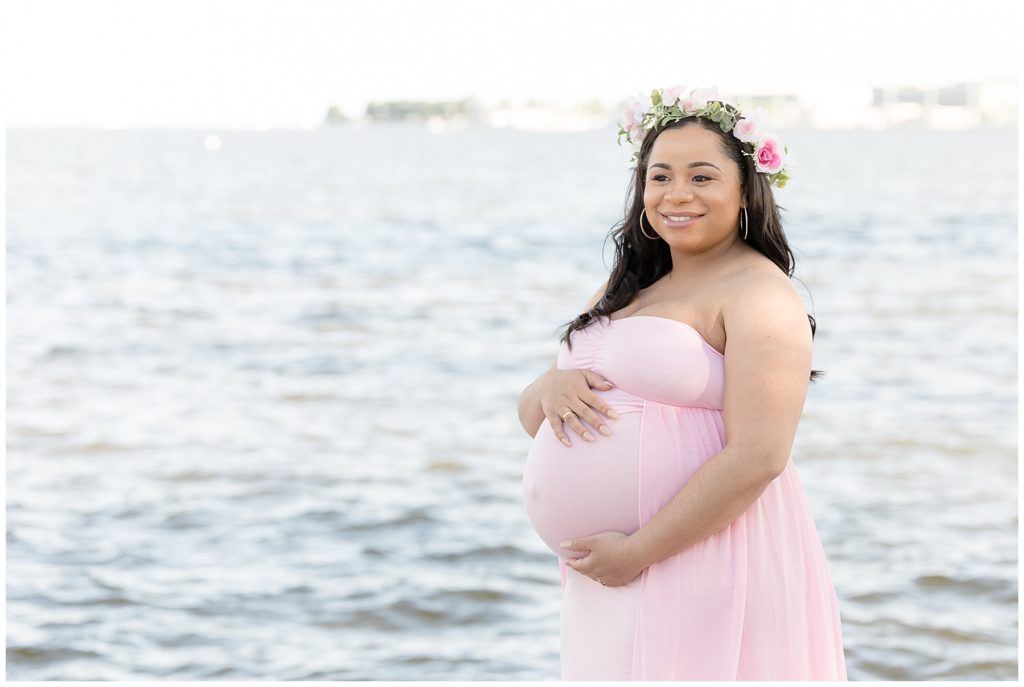 Stunning momma to be dressed in pink with flower crown for beach maternity photos
