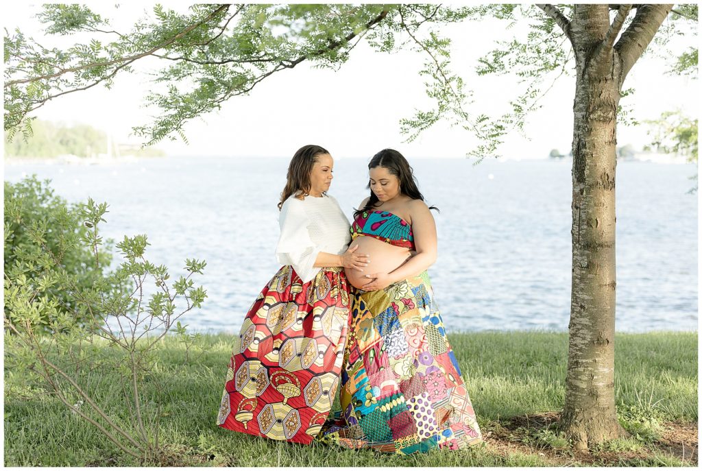 Grandmother, expectant mom and unborn baby stand in tribal dresses at Annapolis waterfront