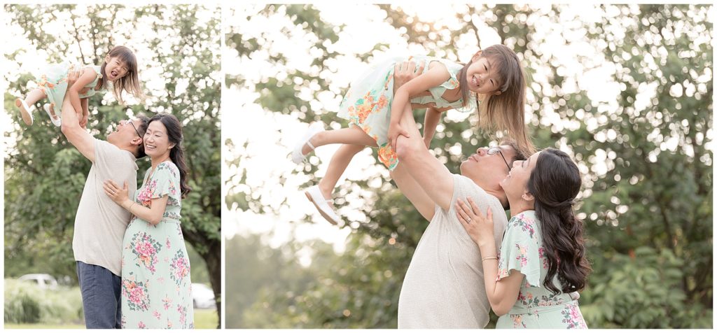 Dad throws laughing daughter in the air while pregnant mom looks on