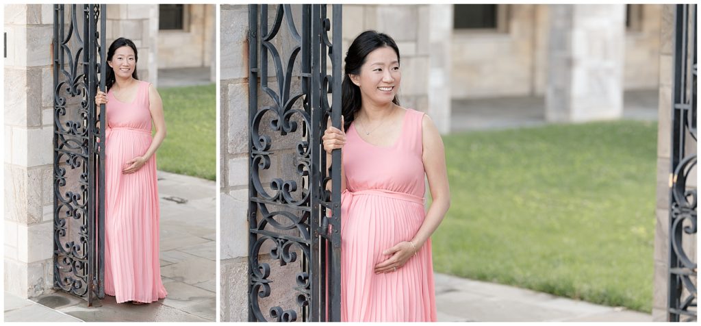 Pregnant mom poses next to black gate during maternity photos