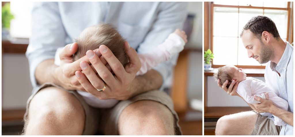 dad holds newborn in his hands, gazes at her face