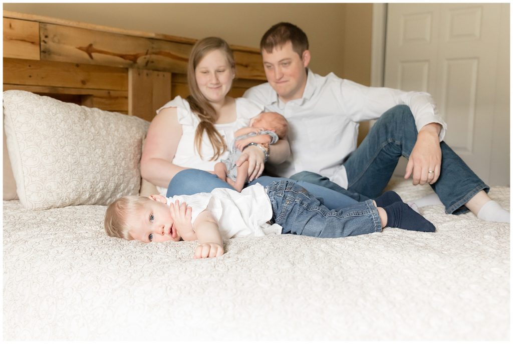 Parents smile at toddler big brother during lifestyle newborn session