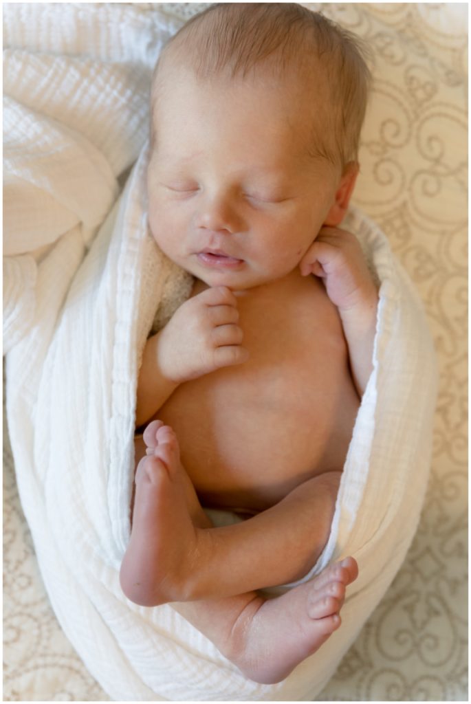 Wrapped newborn posed on his back.