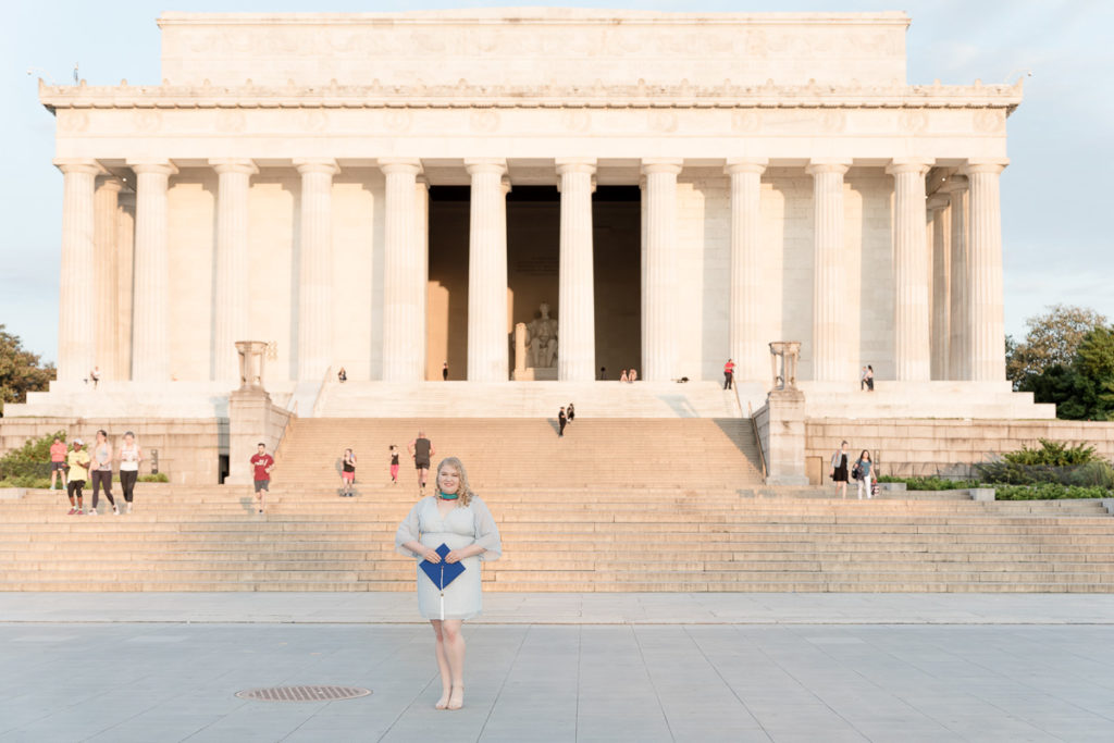 AU grad poses in front of the Lincoln Memorial