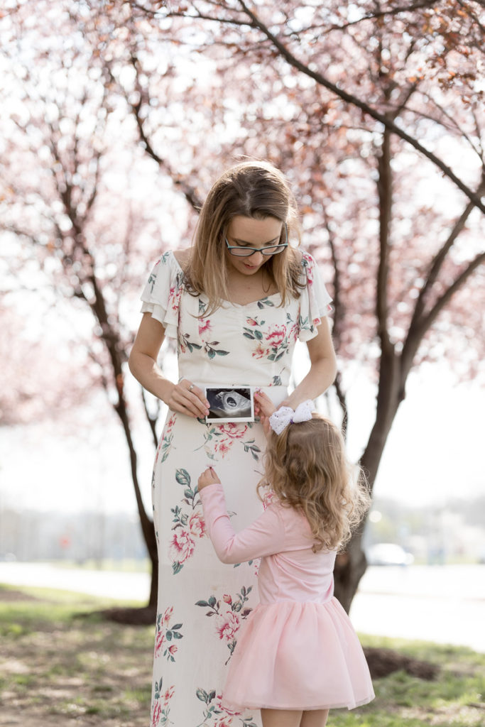 Mom holds ultrasound picture for daughter to see