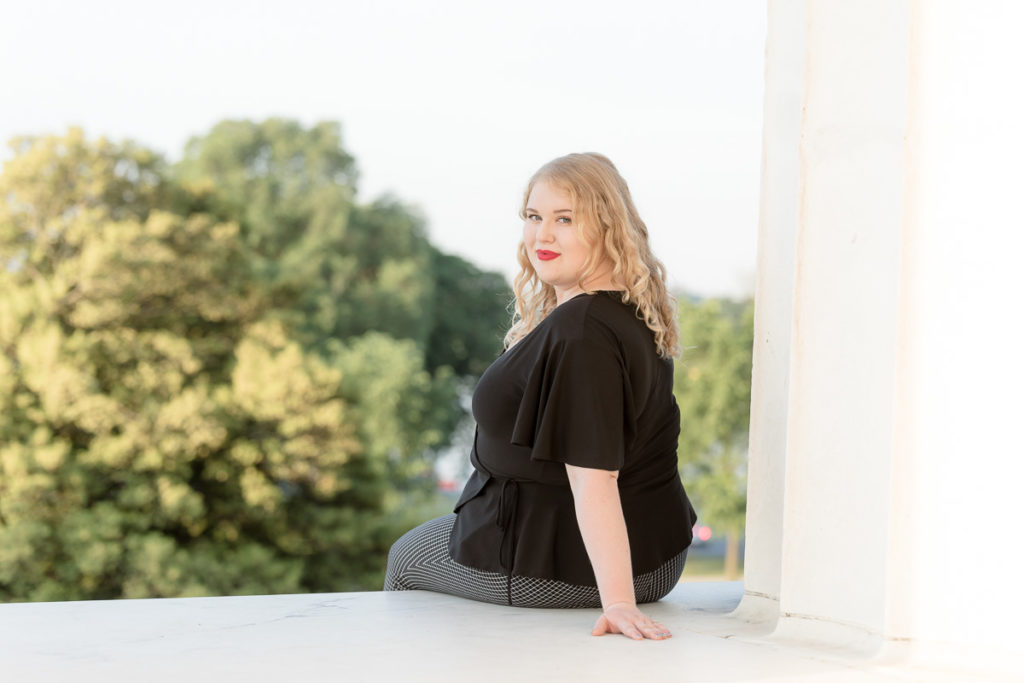 woman looks back over her shoulder in Lincoln Memorial grad session