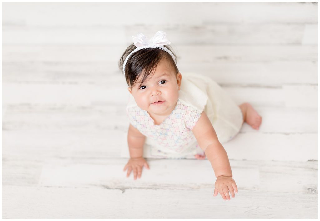 7 month old baby peers up at the camera during her Burtonsville sitter session