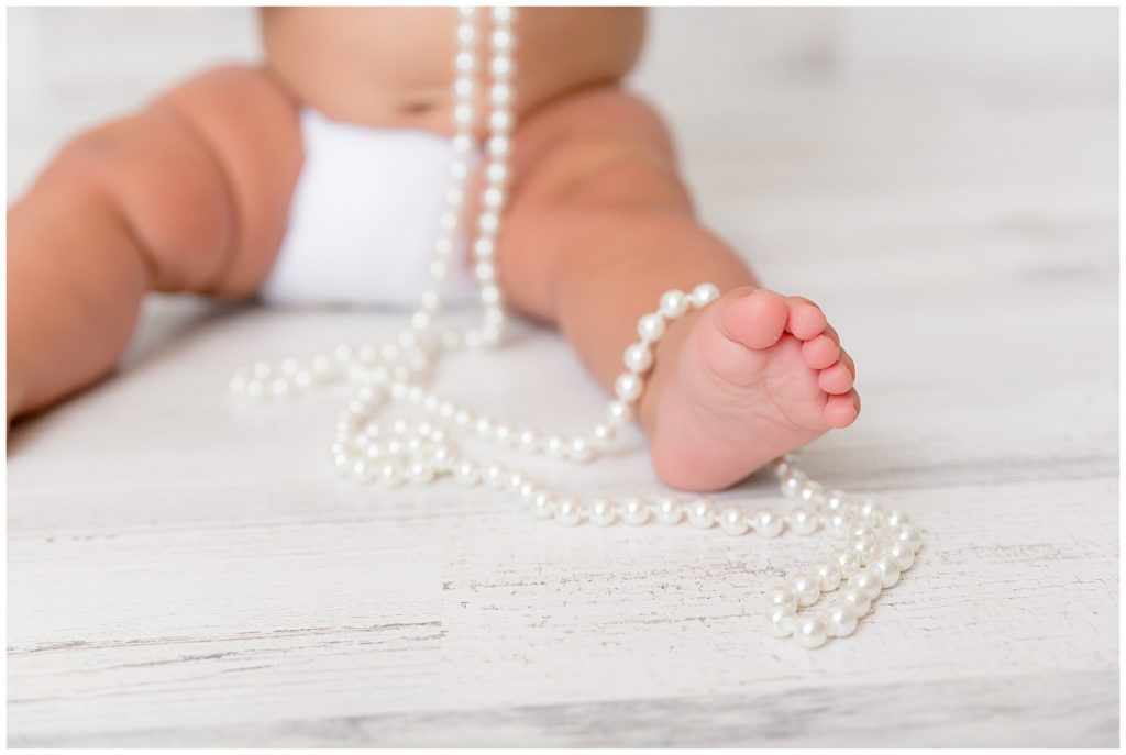 Tiny toes entwined with pearls