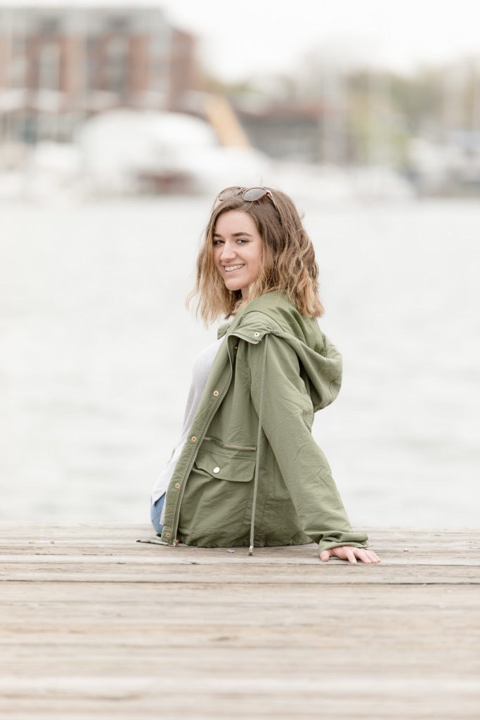 Teenage girl sits on Annapolis dock for senior portraits