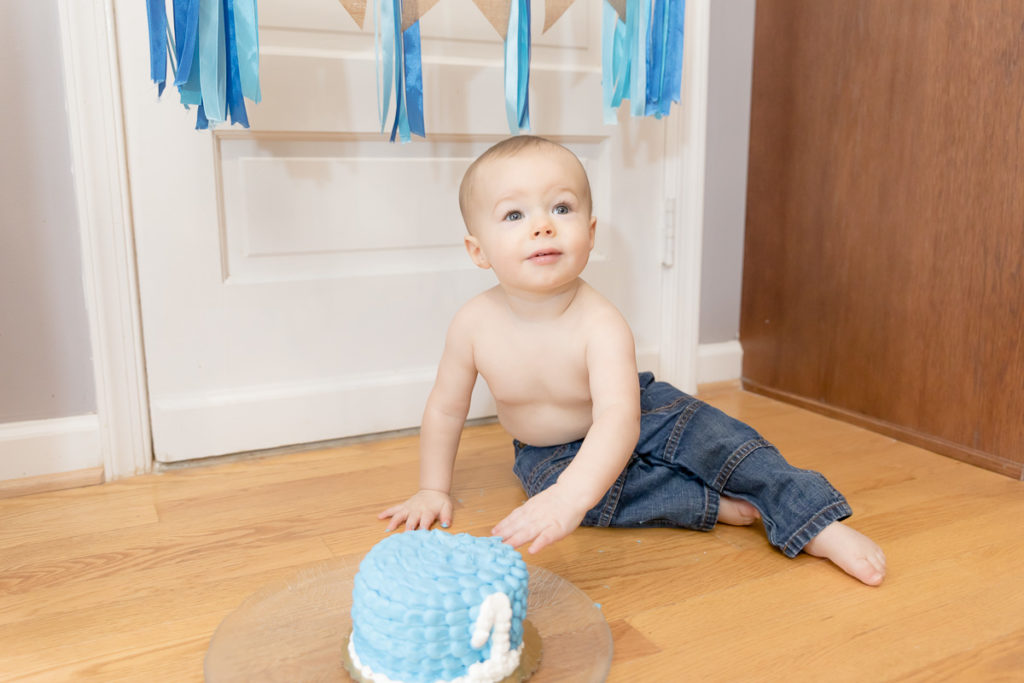 baby boy with blue eyes and blue cake at his cake smash session