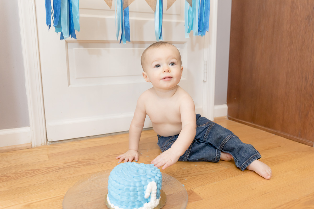 baby boy with blue eyes and blue cake at his cake smash session