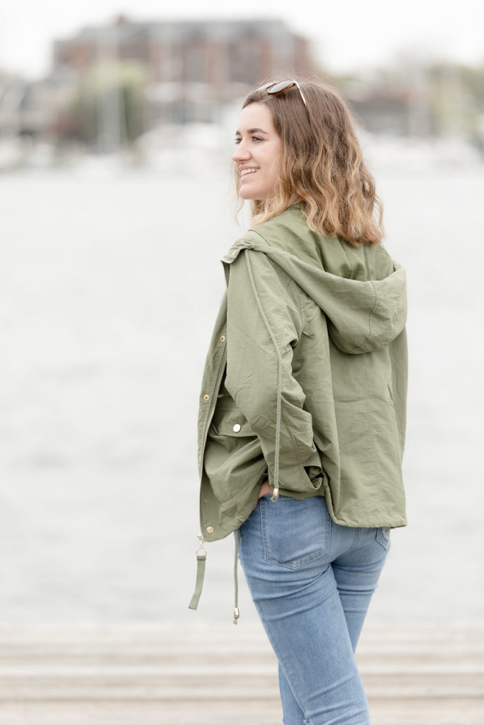 Girl stands on dock with hand tucked in back pocket