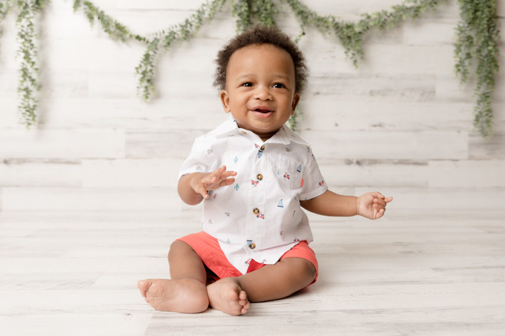 Smiley baby sits up during 6 month photos