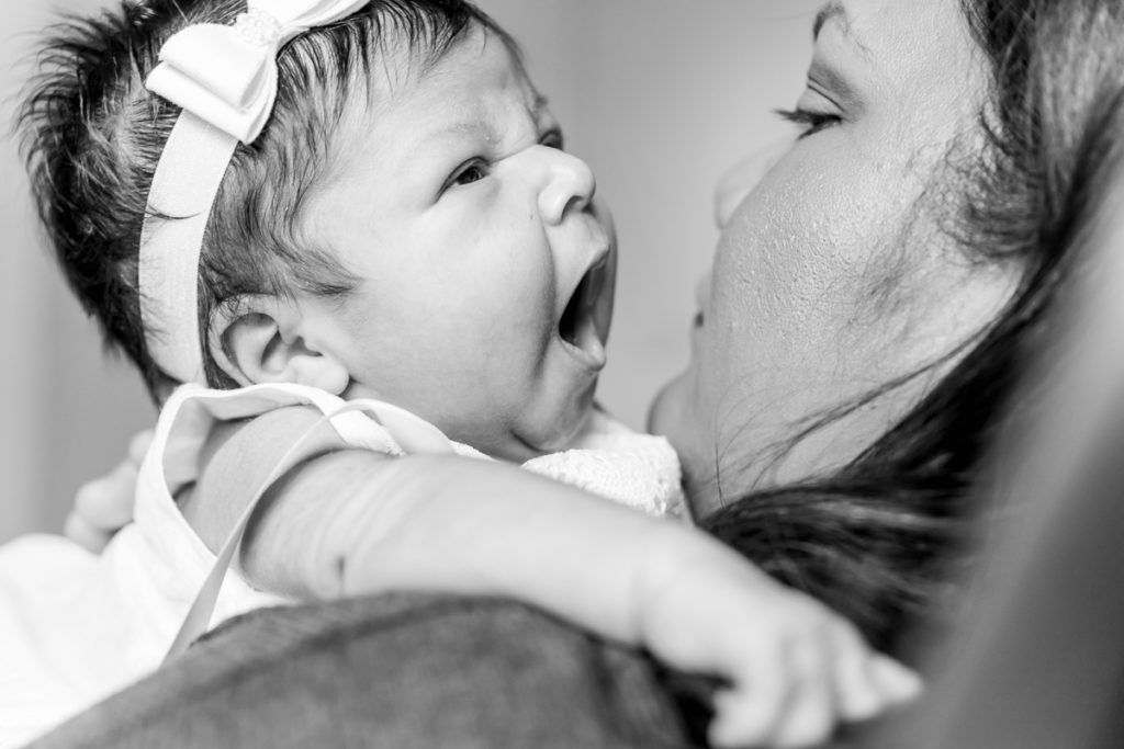 newborn baby yawns on mom's shouler