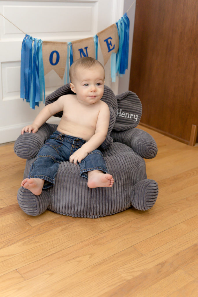 New one year olds poses on elephant chair