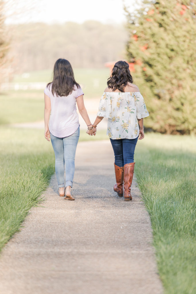 Senior girl walks away holding hands with her sister