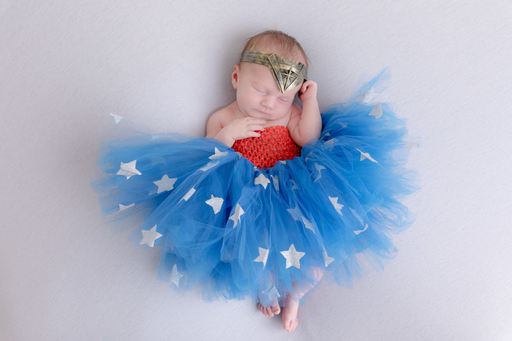 newborn baby in blue and red Wonder Woman costume