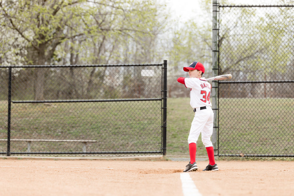 boy stands poised to hit pitched baseball
