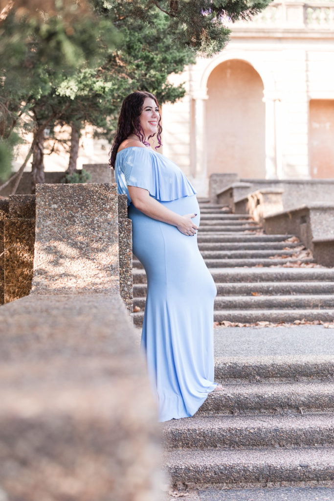 pregnant woman stands on steps of Meridian Hill Park 
