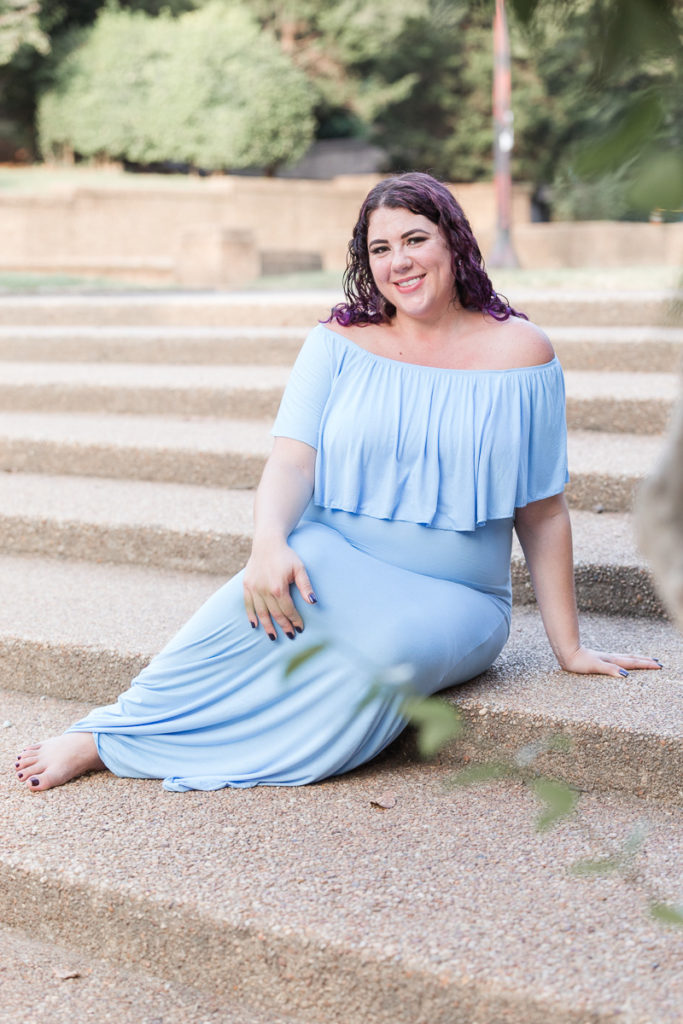pregnant woman in blue dress sits on steps