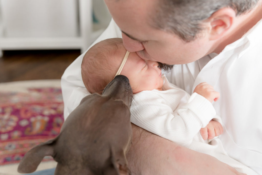 dad and dog kiss baby