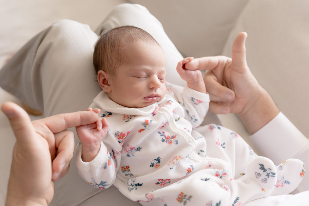 dad holds baby's hands in DC lifestyle newborn photos