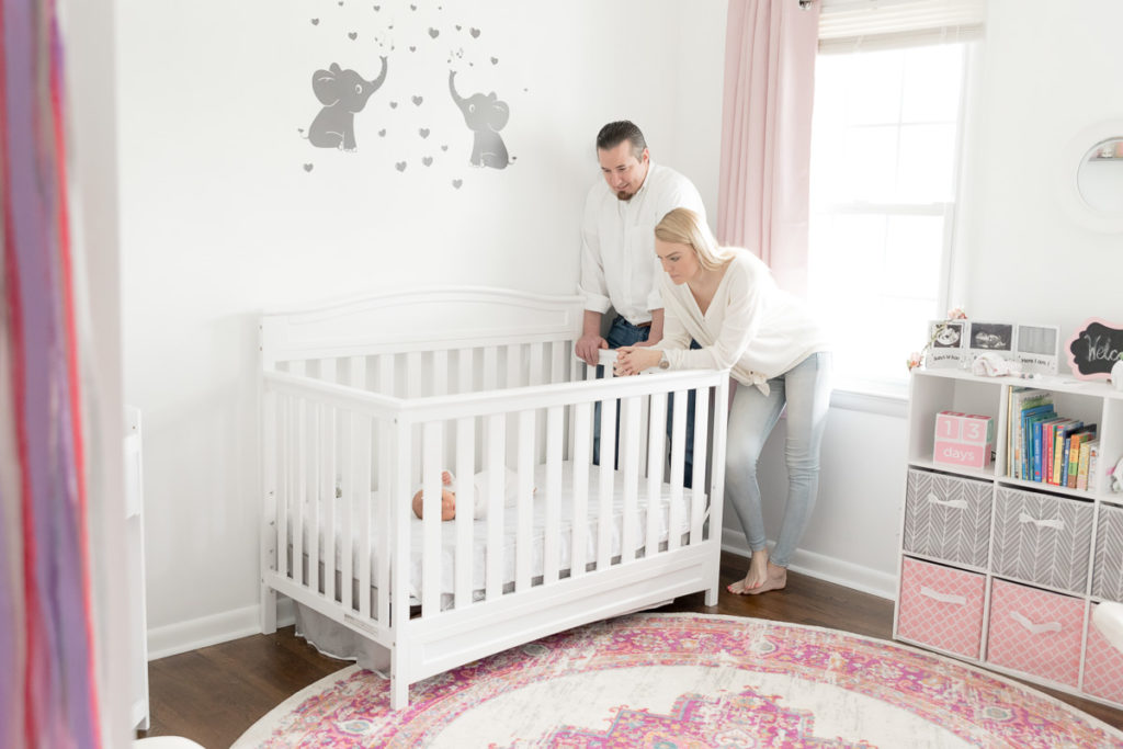parents look at baby lying in crib