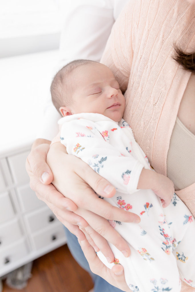 newborn girl sleeps in mom's arms