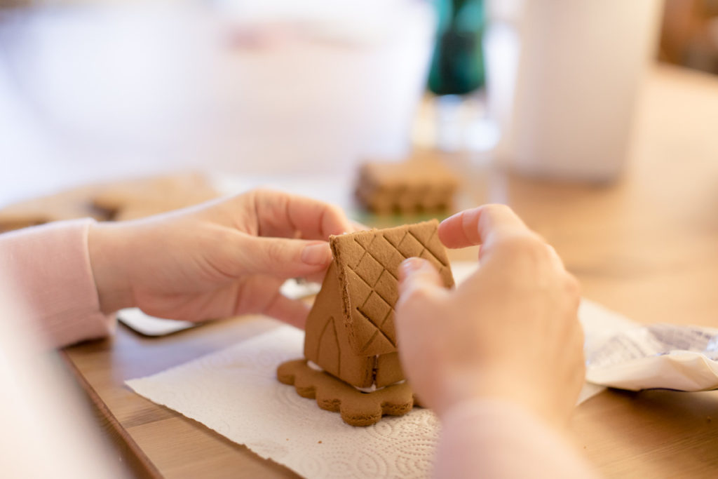 adult hands craft gingerbread house