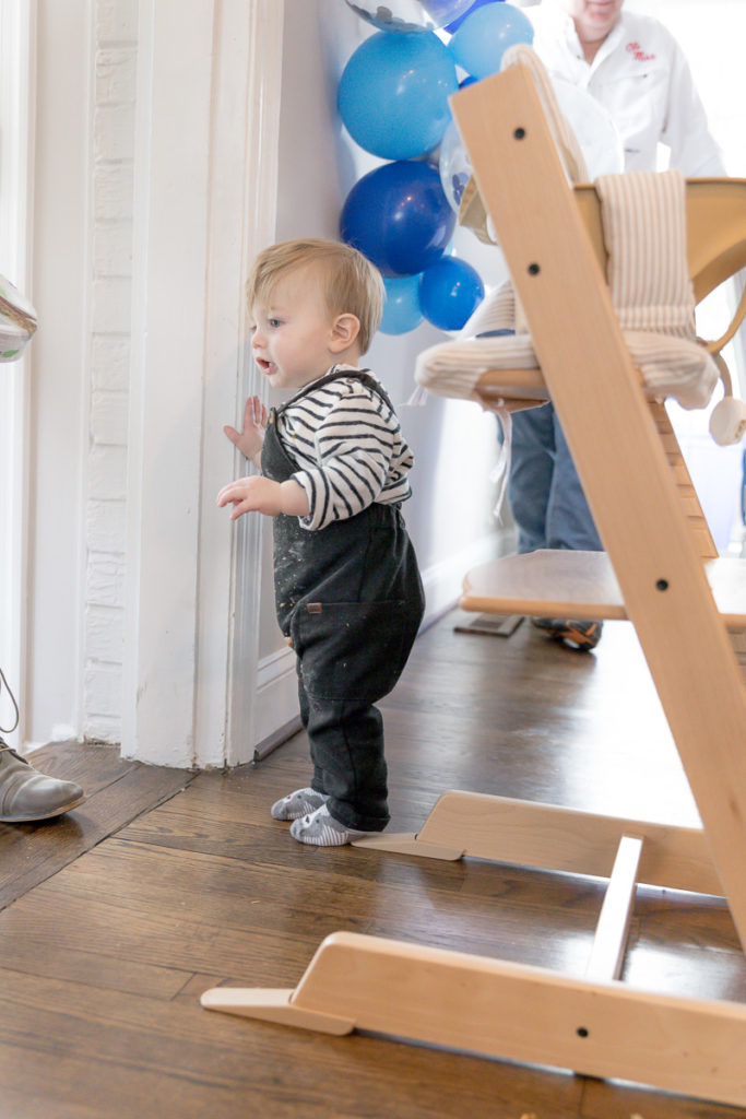 Toddler checks on guests in First birthday photos