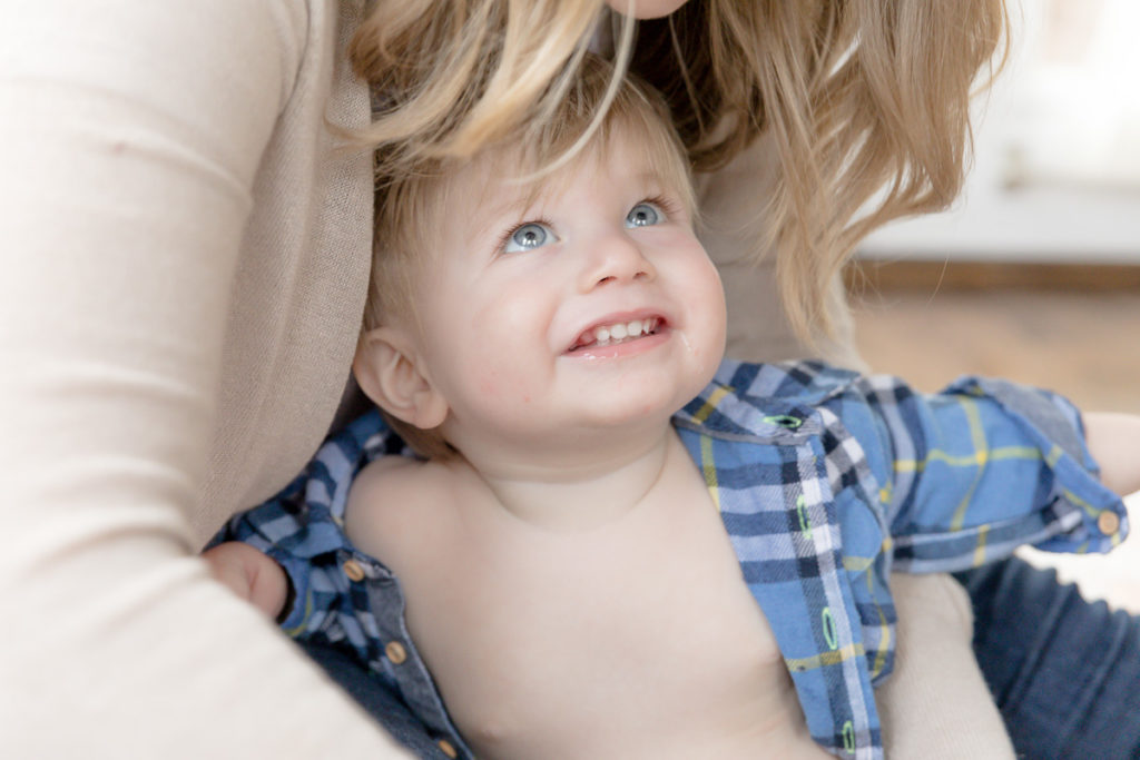 one year old grins up at his momma during his First birthday photos