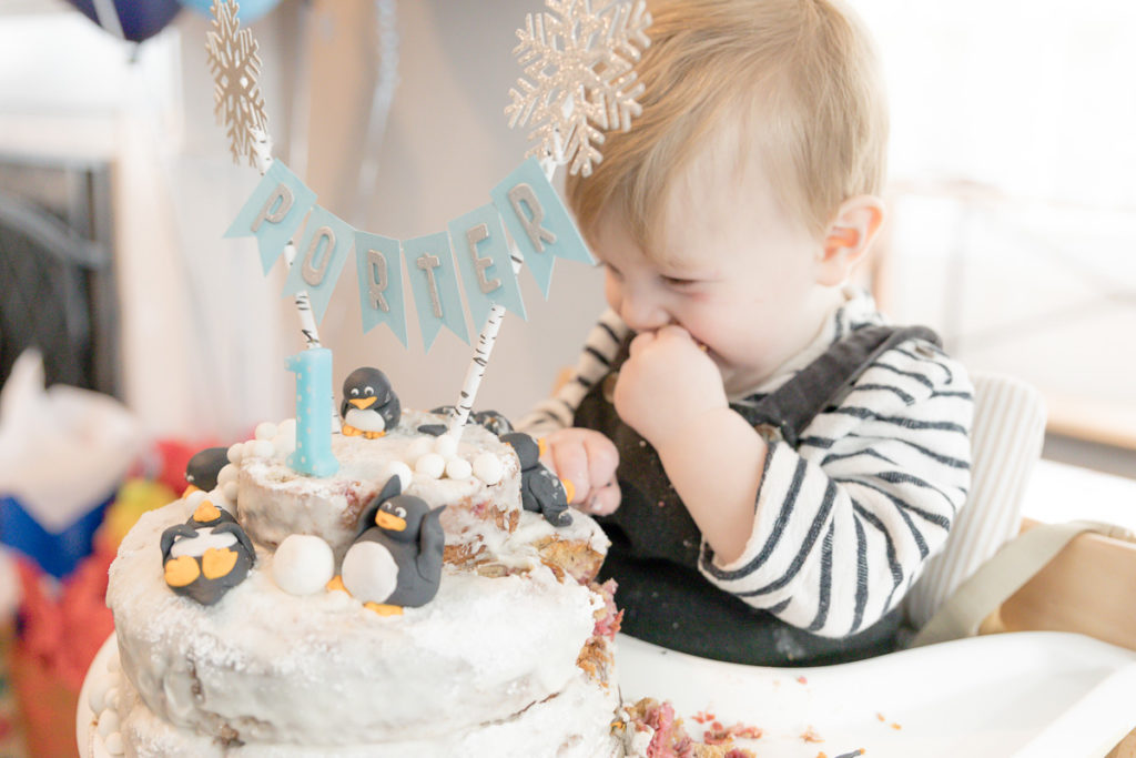 Birthday boy giggles over first birthday smash cake.

