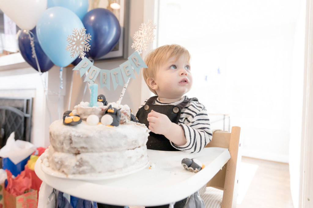 boy looks at mom during first birthday cake smash