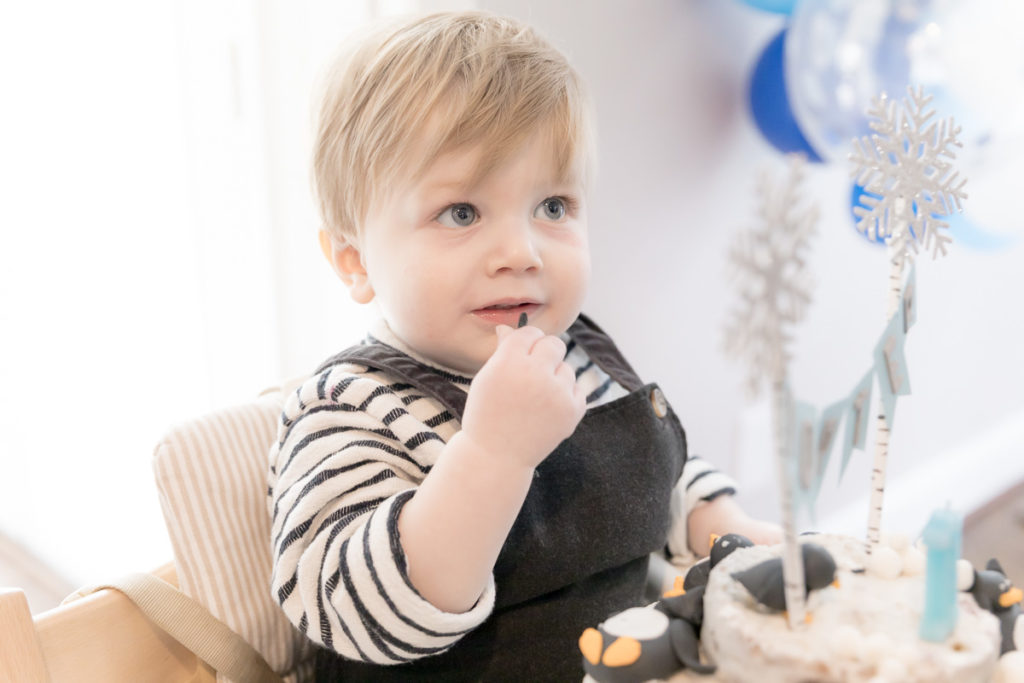 boy sits in high chair during cake smash