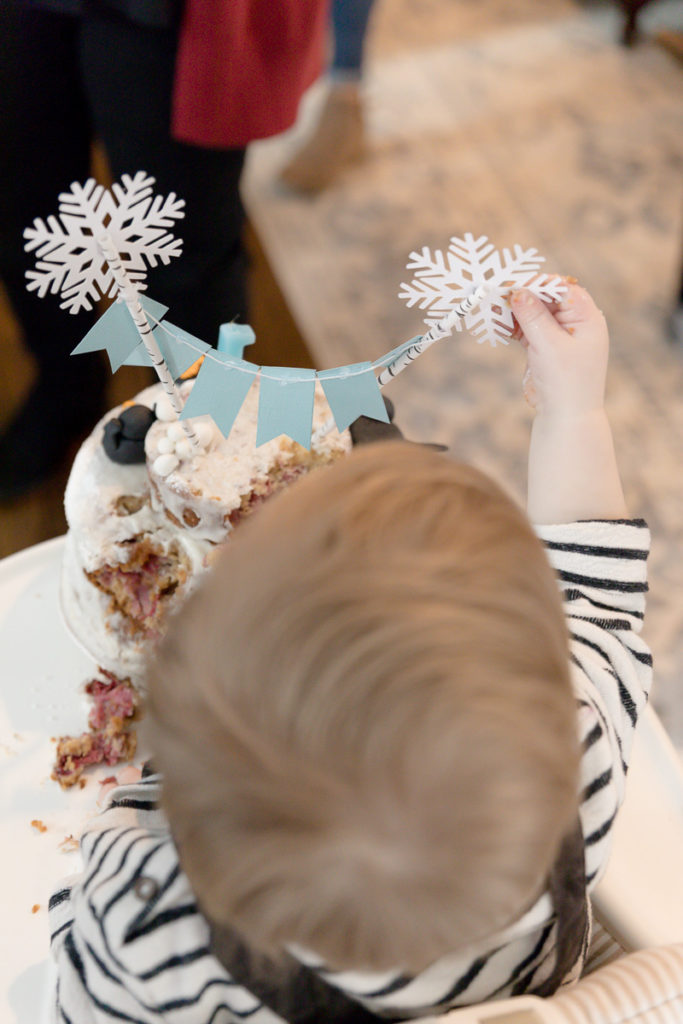 toddler plays with smash cake decorations 