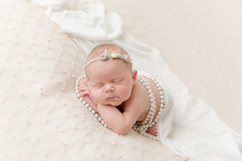 newborn girl posed with pearls