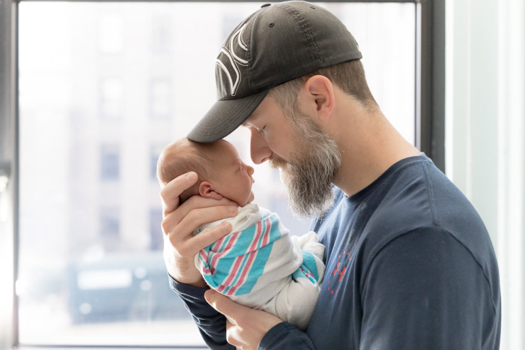 new dad nose to nose with son in newborn photos right after birth