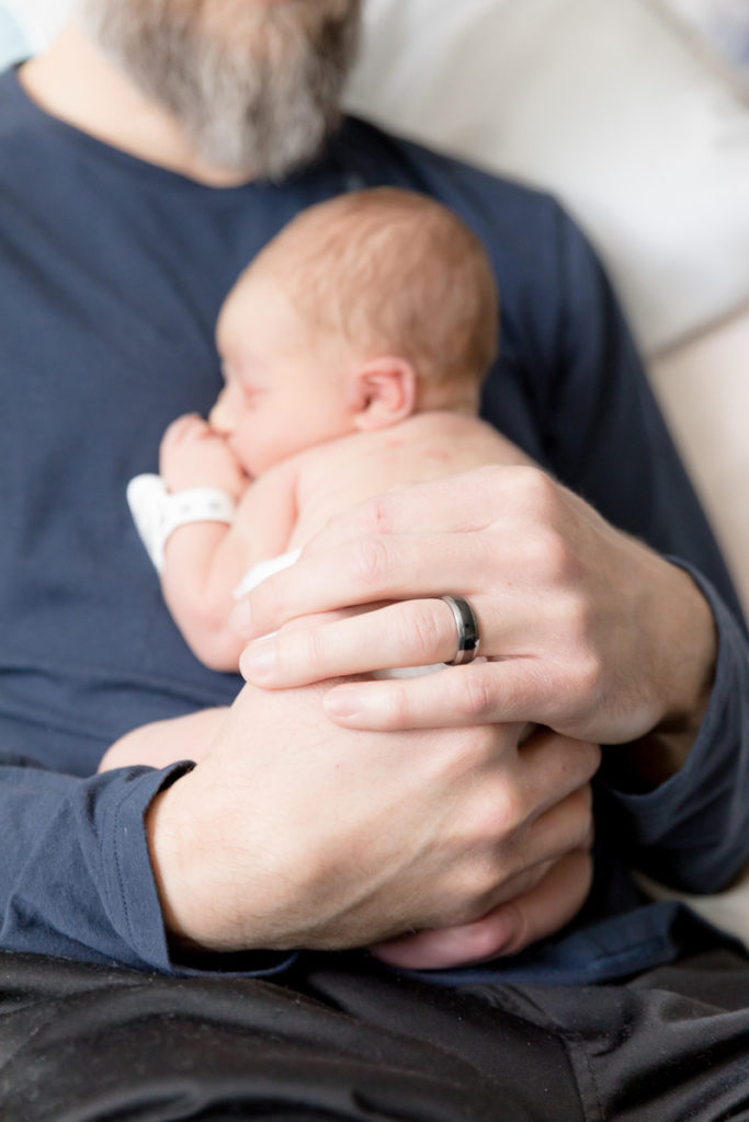 image of dad's hands holding newborn son