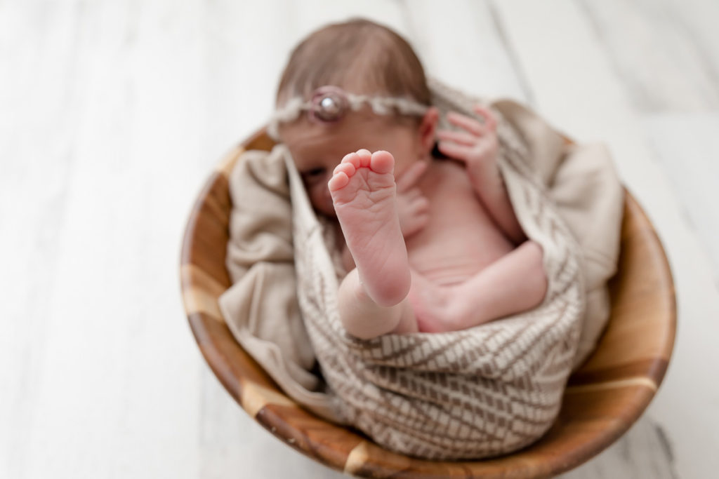 tiny newborn foot kicks in Maryland newborn photography studio

