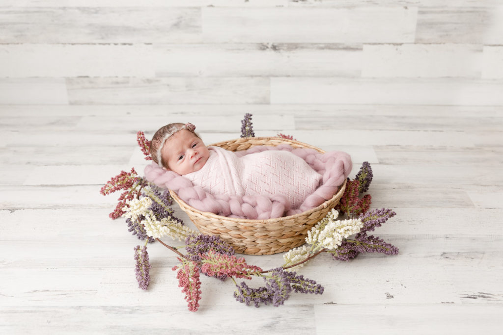 Preemie newborn peeks at photographer in Maryland newborn photography studio

