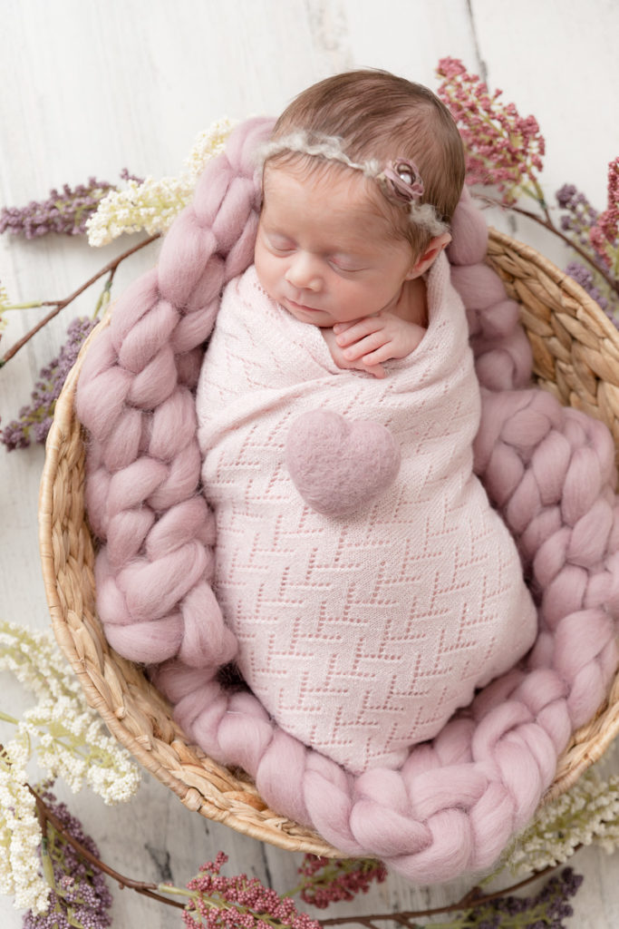 hearts and flowers surround newborn baby girl in Maryland newborn photography studio