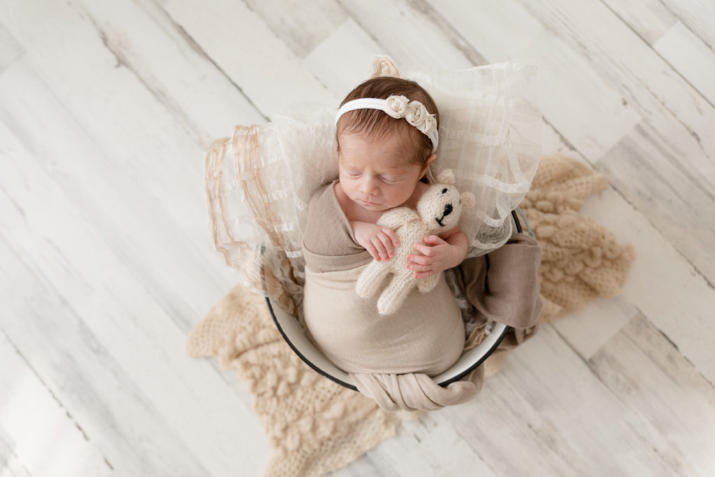 baby girl clutches lovey during newborn photos