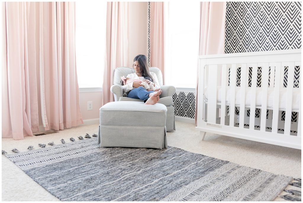 mom and baby sit in beautiful nursery decor