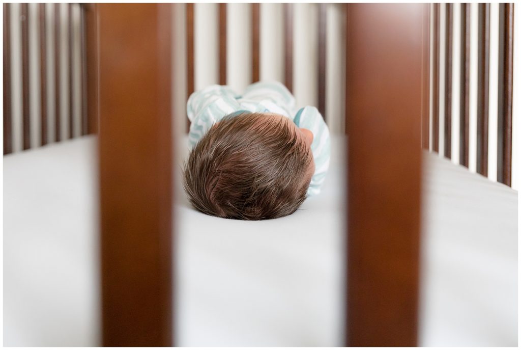 newborn in crib in newborn photos at home