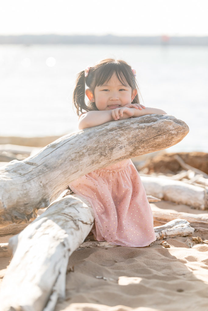 preschooler props her chin on driftwood
