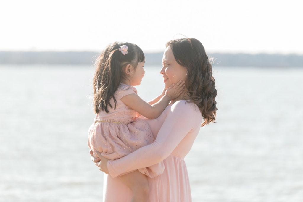 mom hold daughter in maternity photo session