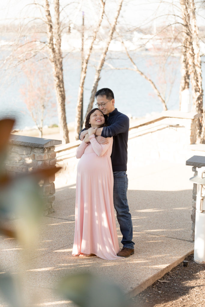 husband and wife embrace, National Harbor maternity photos
