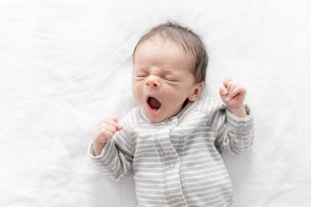new baby yawns on parent's bed